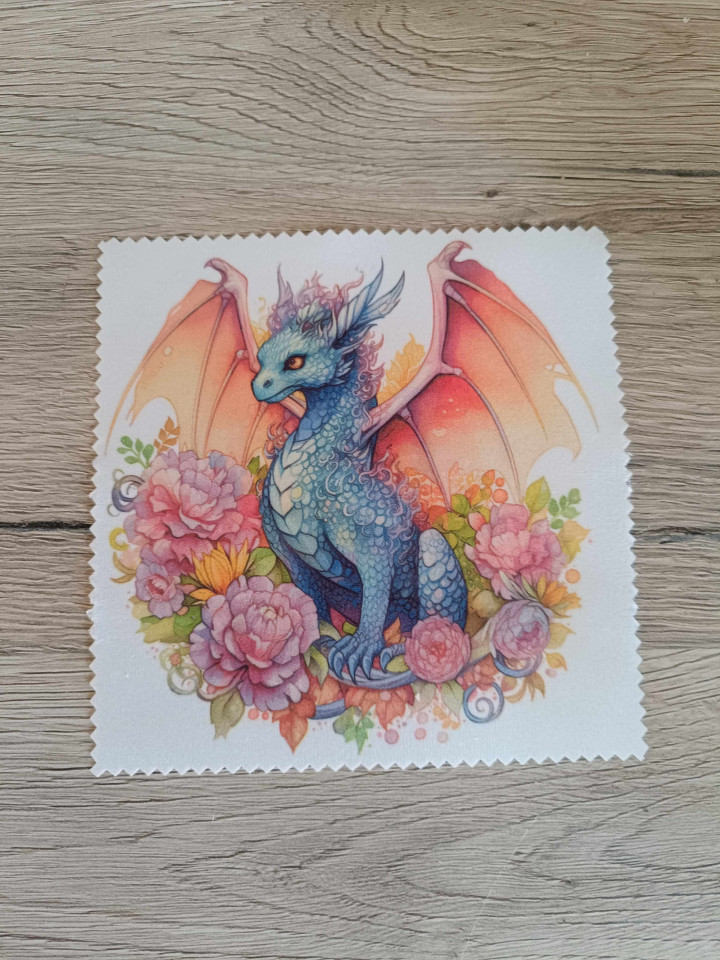 Lingette microfibre blanche à bords crantés illustrée d'un dragon bleu aux ailes orangées entouré de fleurs