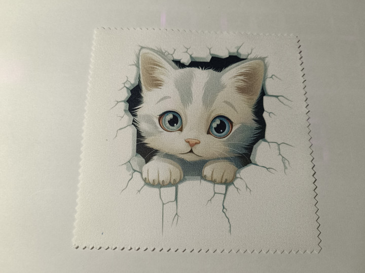 Lingette microfibre blanche illustrée d'un chaton aux yeux bleus sortant d'un mur fissuré