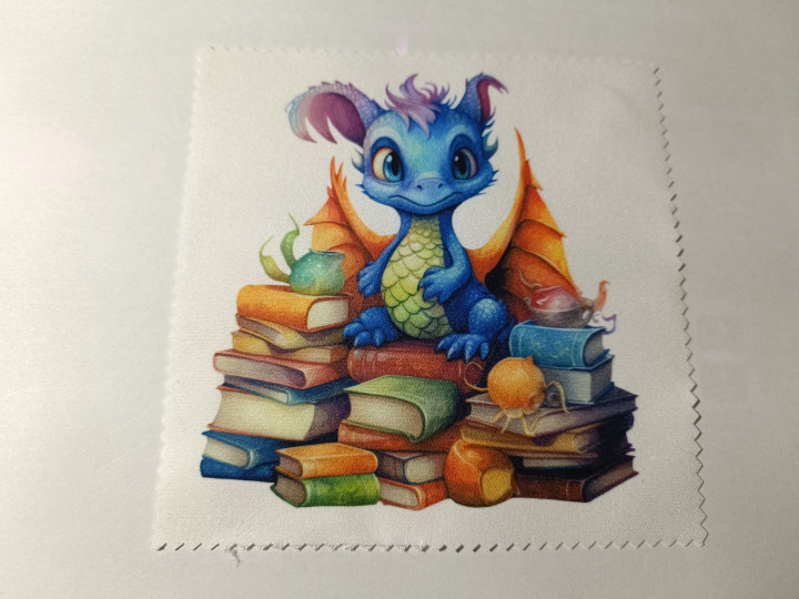 Lingette microfibre illustrée d'un petit dragon bleu assis sur des piles de livres