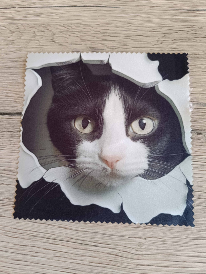 Lingette microfibre carrée avec motif en trompe-l'œil d'un chat noir et blanc passant sa tête à travers une déchirure