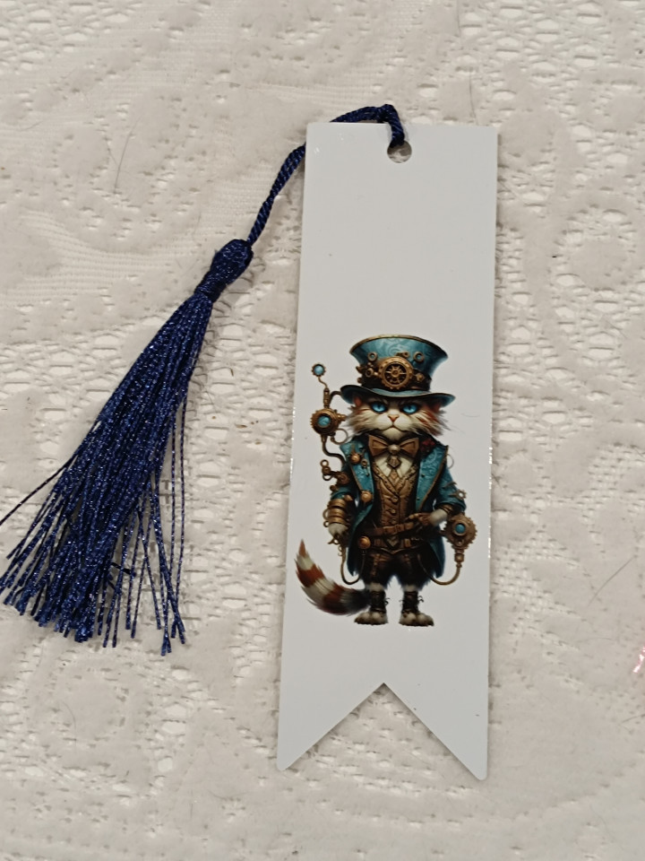 Marque-page blanc orné d'un chat en costume steampunk bleu et d'un pompon bleu