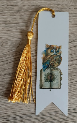 Marque-page blanc illustré d'un hibou steampunk sur un grimoire avec pompon doré