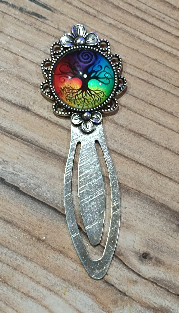 Marque-page en métal argenté avec cabochon rond illustrant un arbre de vie sur fond multicolore