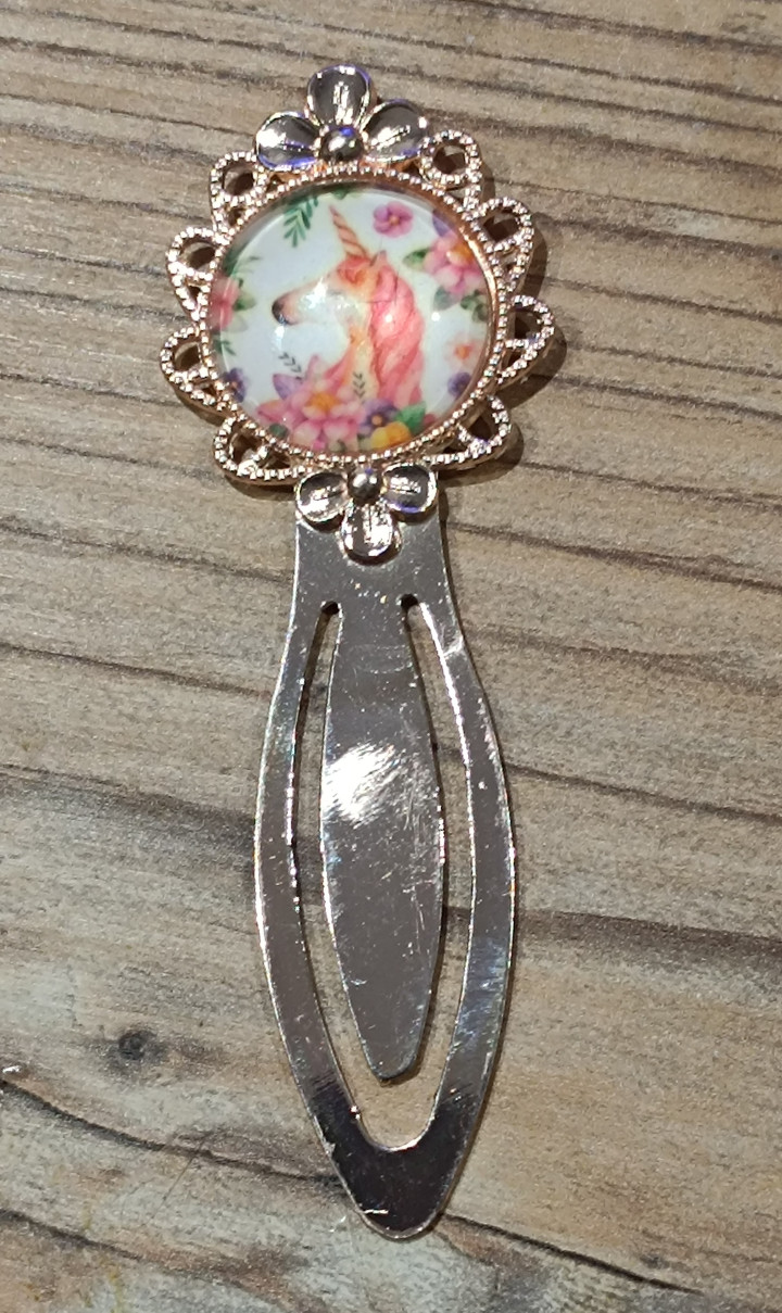 Marque-page en métal brillant avec médaillon floral illustré d'une tête de licorne