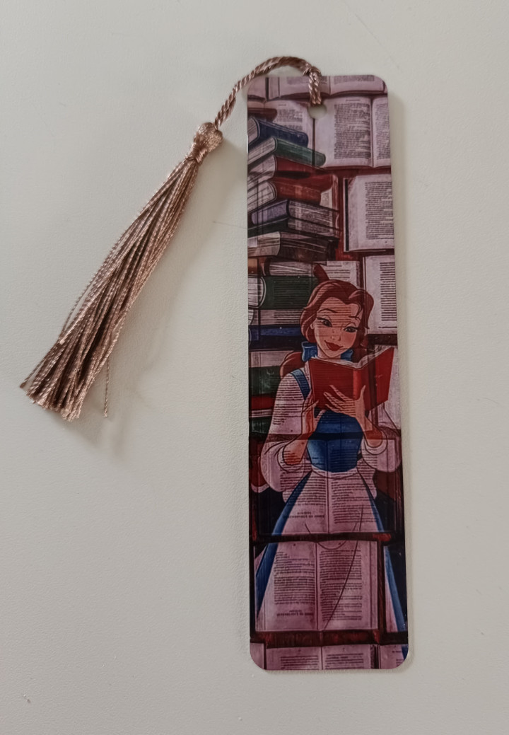 Marque-page illustré représentant une jeune lectrice en robe bleue lisant un livre rouge au milieu d'une bibliothèque