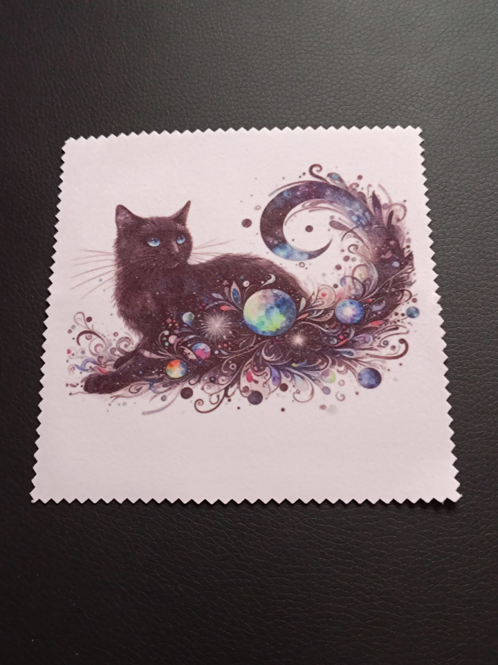 Lingette microfibre blanche aux bords dentelés ornée d'un chat noir entouré de motifs cosmiques et planètes