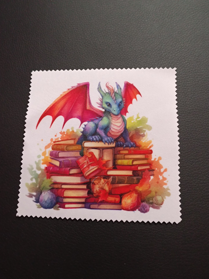 Lingette microfibre blanche ornée d'un petit dragon coloré perché sur une pile de livres anciens