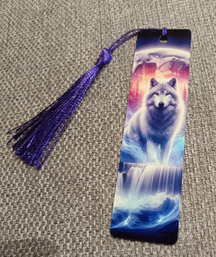 Marque-page illustré d'un loup blanc au-dessus d'une cascade avec pompon violet