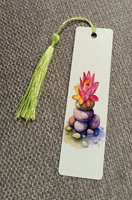 Marque-page blanc illustré de galets empilés et d'une fleur de lotus rose avec un pompon vert clair