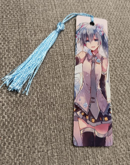 Marque-page illustré d'une fille style anime aux cheveux bleus avec pompon assorti