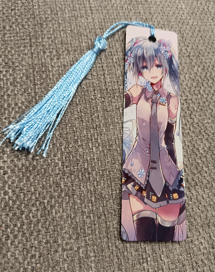 Marque-page illustré d'une fille style anime aux cheveux bleus avec pompon assorti