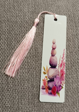 Marque-page blanc orné de galets empilés et de fleurs roses avec pompon rose