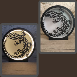 Lampe ronde noire avec silhouette de lézard ajouré, allumée et éteinte