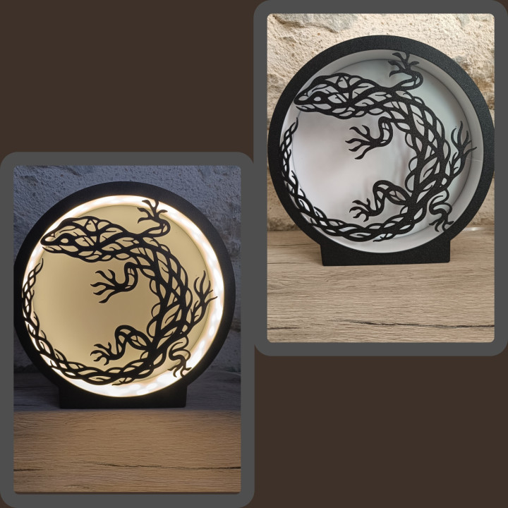 Lampe ronde noire avec silhouette de lézard ajouré, allumée et éteinte