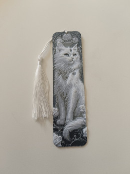 Marque-page en impression 3D représentant un chat mystique blanc en relief avec un pompon