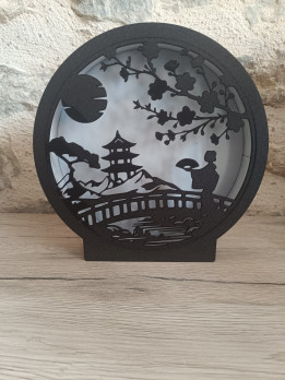 Lampe veilleuse ronde en impression 3D noire représentant une silhouette de paysage asiatique avec pagode et cerisier