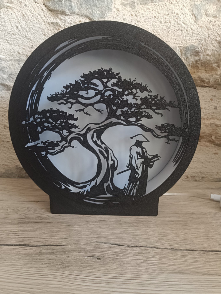 Lampe veilleuse ronde en impression 3D avec silhouette noire de guerrier sous un arbre éclairée par une lumière chaude