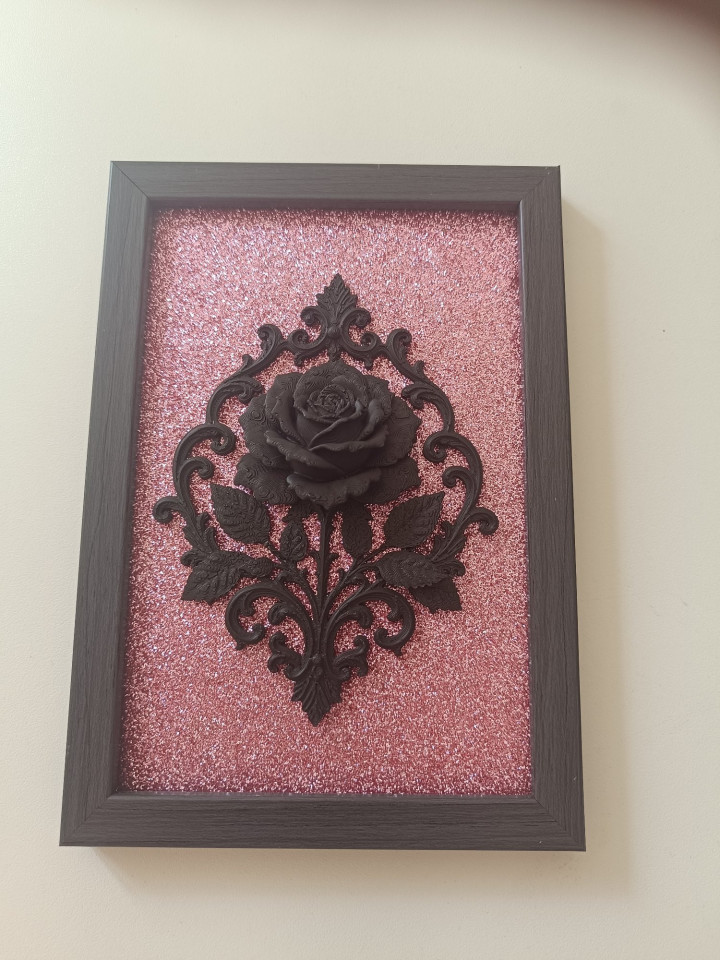 Cadre rectangulaire sombre avec rose noire en relief 3D sur fond rose pailleté