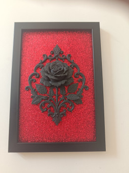 Cadre noir avec rose baroque noire en relief sur fond rouge scintillant