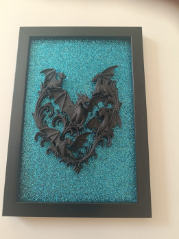 Cadre noir avec dragons en impression 3D noire sur fond turquoise scintillant