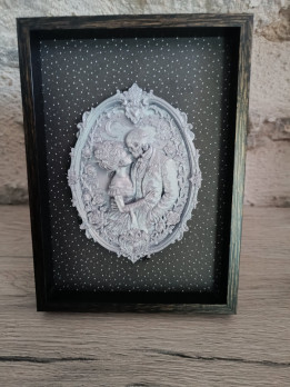 Cadre noir avec médaillon en impression 3D représentant un couple de squelettes enlacés