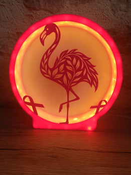 Lampe circulaire rose allumée avec silhouette de flamant rose et rubans