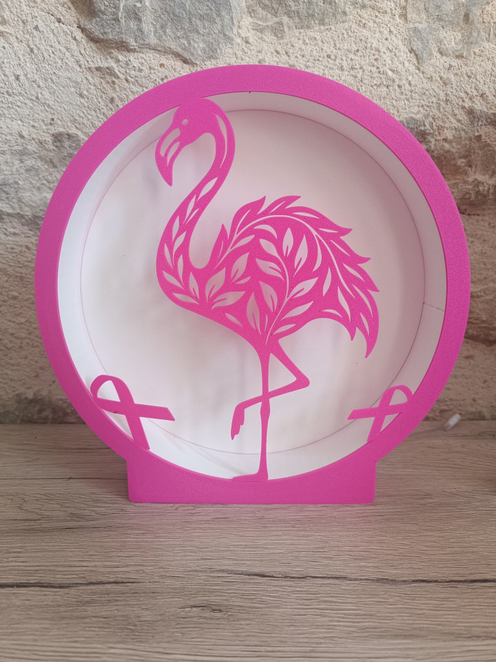 Lampe circulaire rose allumée avec silhouette de flamant rose et rubans