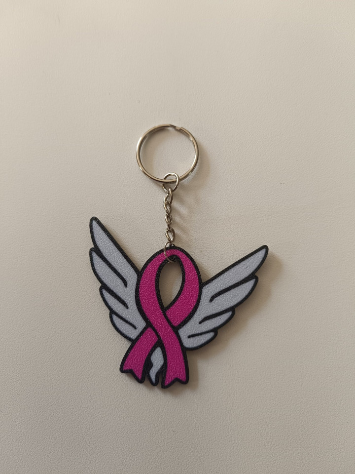 Porte-clés en impression 3D avec un ruban rose vif entouré d'ailes blanches aux contours noirs