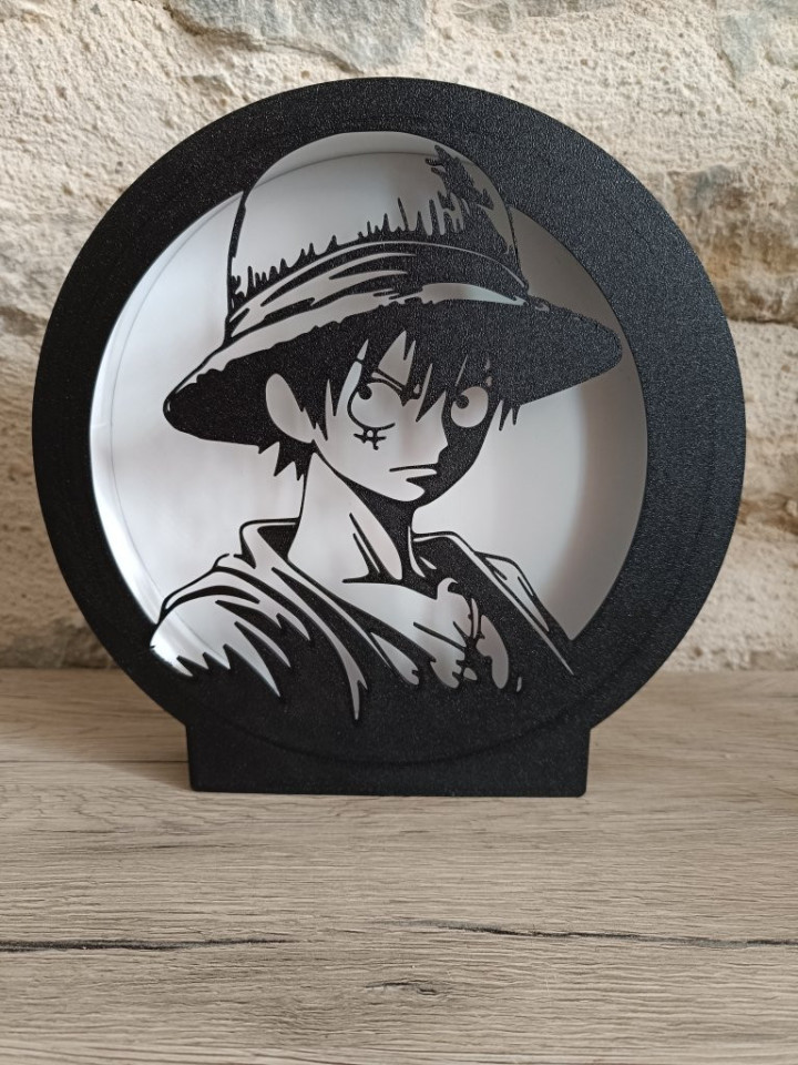 Lampe veilleuse circulaire noire imprimée en 3D avec silhouette lumineuse de pirate au chapeau de paille