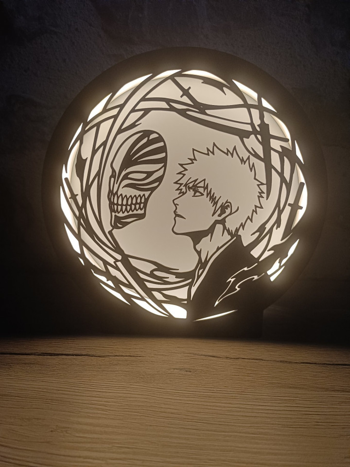 Veilleuse circulaire LED montrant la silhouette d'un guerrier de profil face à un masque squelettique