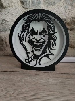 Lampe circulaire en impression 3D avec silhouette noire d'un clown au rire démoniaque sur fond blanc