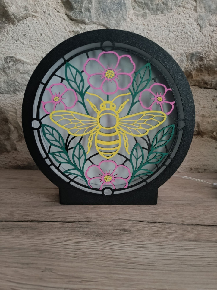 Lampe veilleuse ronde allumée avec motif d'abeille et de fleurs façon vitrail