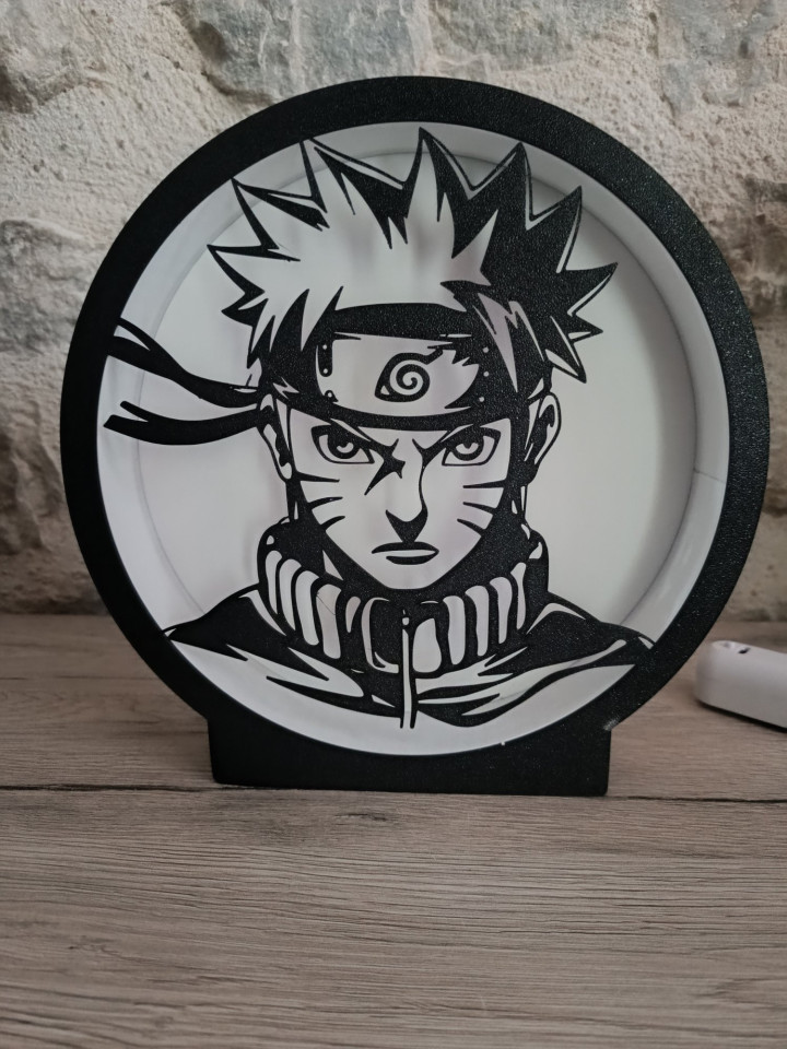 Lampe veilleuse circulaire noire en impression 3D avec ruban LED illuminant la silhouette d'un jeune ninja