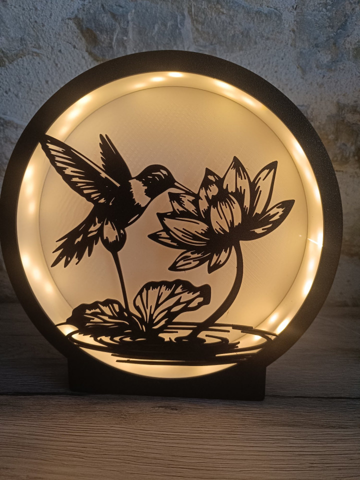 Veilleuse ronde en impression 3D avec silhouette noire de colibri et fleur de lotus illuminée par des LED