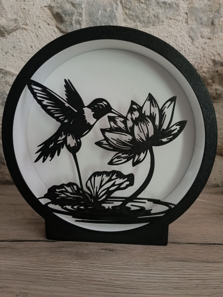 Veilleuse ronde en impression 3D avec silhouette noire de colibri et fleur de lotus illuminée par des LED