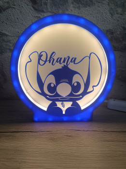 Veilleuse circulaire lumineuse bleue avec silhouette de créature aux grandes oreilles et inscription Ohana