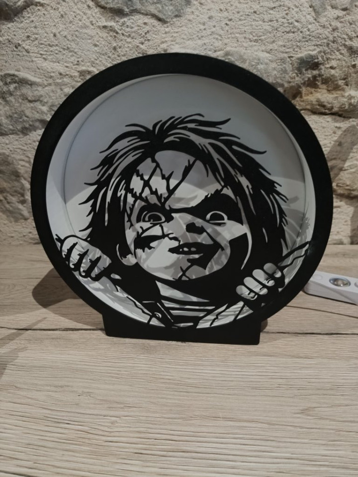 Lampe circulaire lumineuse en impression 3D avec silhouette de poupée balafrée tenant une lame