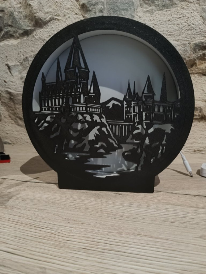 Veilleuse circulaire noire rétroéclairée avec silhouette de château fantastique