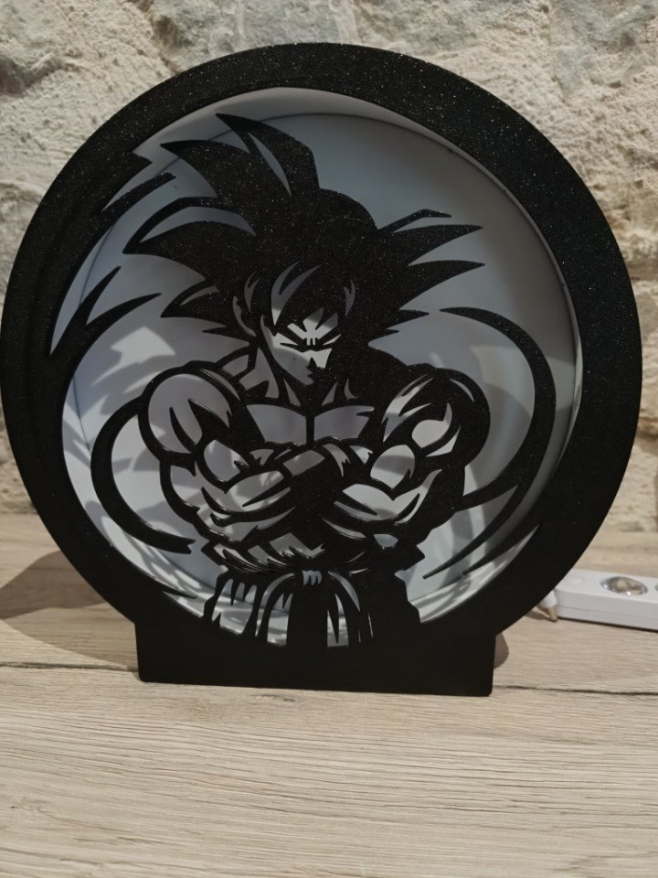 Lampe veilleuse circulaire noire rétroéclairée avec silhouette découpée de guerrier musclé aux cheveux hérissés