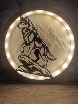 Lampe circulaire avec silhouette de loup sur un rocher et montagnes rétroéclairées par des LED