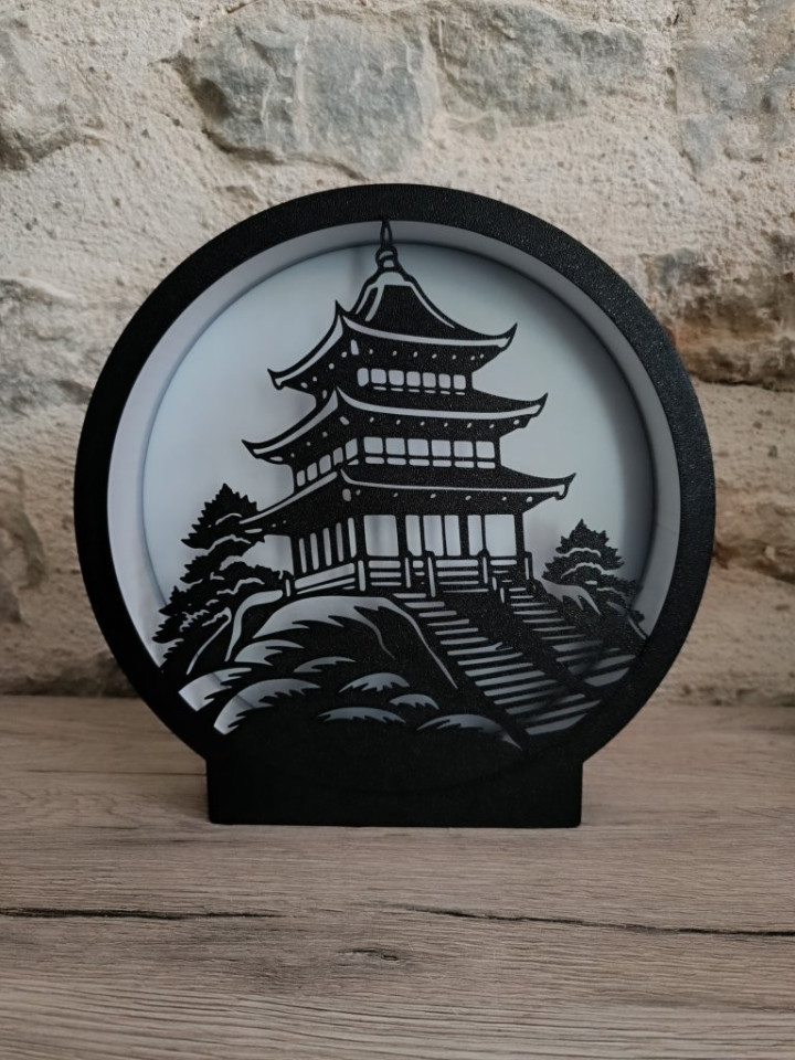 Lampe ronde noire avec silhouette de pagode asiatique éclairée par un ruban LED