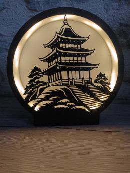 Lampe ronde noire avec silhouette de pagode asiatique éclairée par un ruban LED