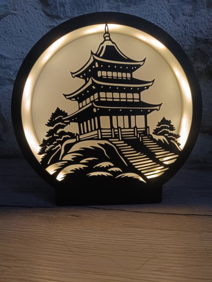 Lampe ronde noire avec silhouette de pagode asiatique éclairée par un ruban LED